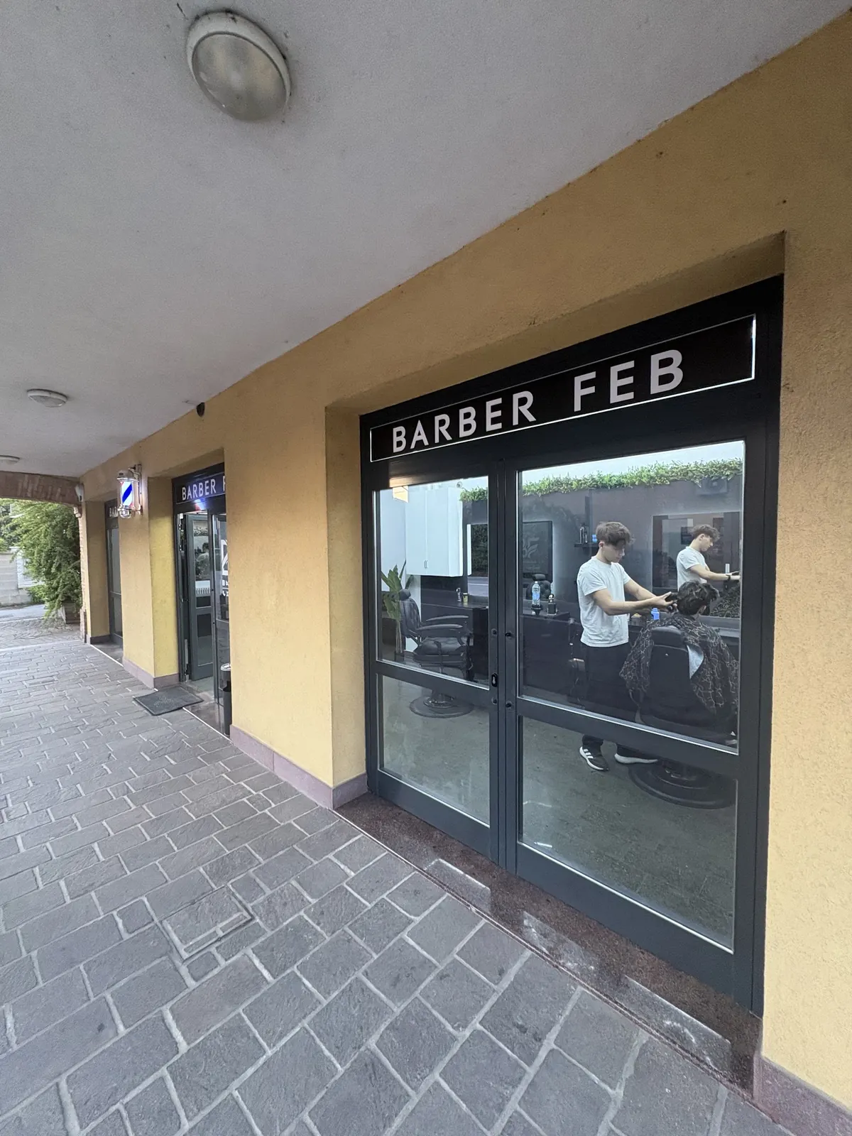 La vetrina di Barber Feb di giorno, sotto il portico